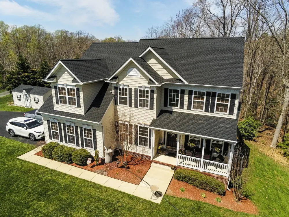 Aerial view of a large two-story colonial home in Hughesville, MD with a brand new charcoal architectural shingle roof