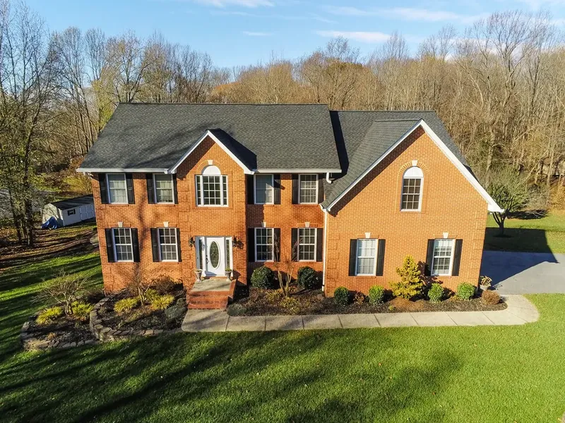 Charcoal architectural asphalt shingle roof installed on a two-story brick colonial home in Bowie, MD — roof replacement project in Bowie, MD by Summit Exteriors