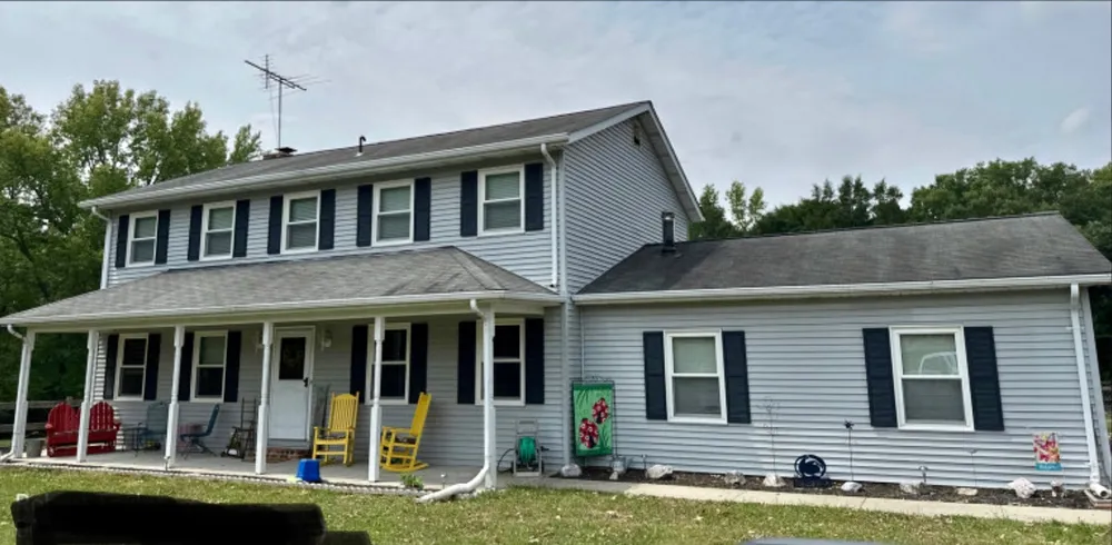 Two-story Hollywood, MD colonial with faded light blue vinyl siding before a Summit Exteriors siding replacement