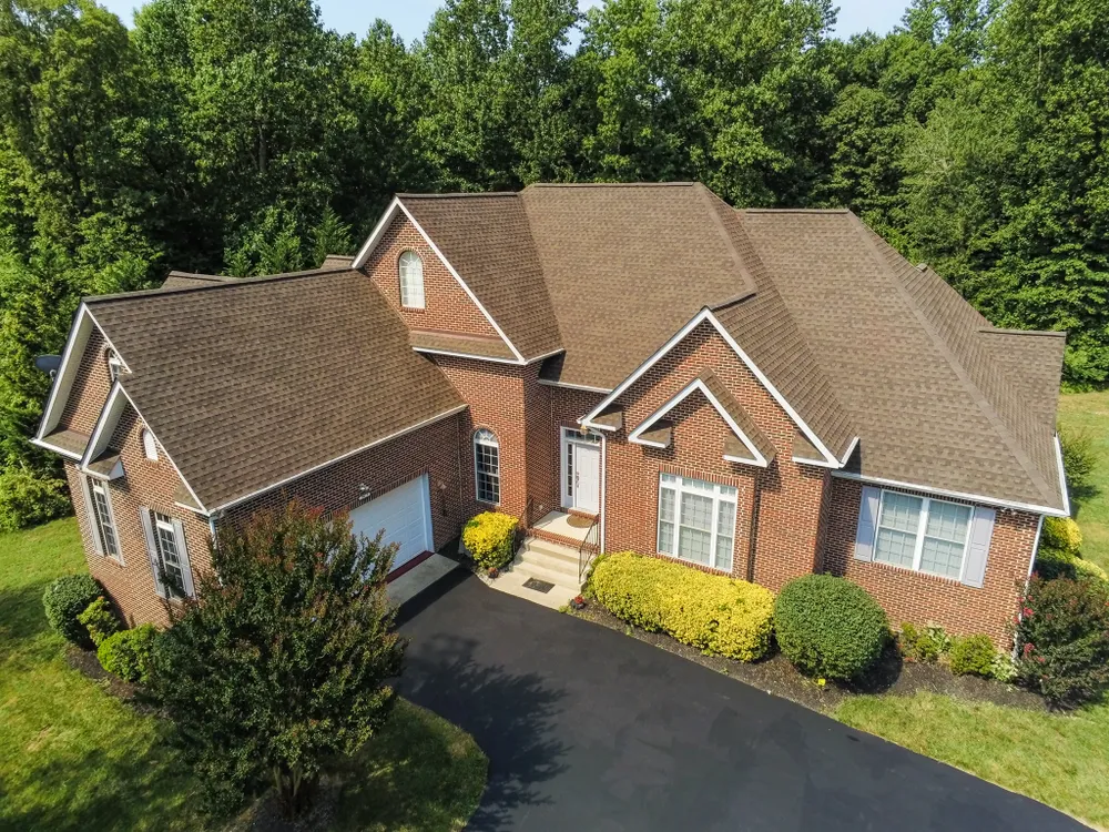 Aerial view of a brick colonial home in Huntingtown, MD with a freshly installed brown architectural shingle roof