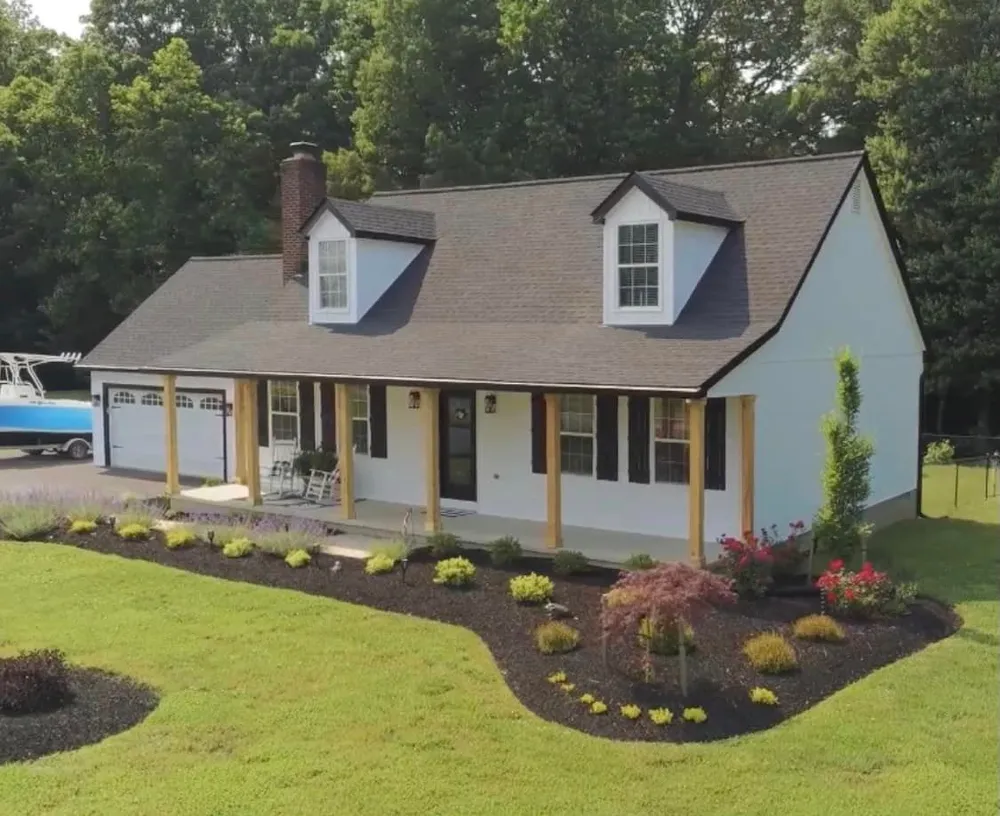 White Cape Cod home in Mechanicsville, MD with two dormers, a wraparound porch and a new brown architectural shingle roof