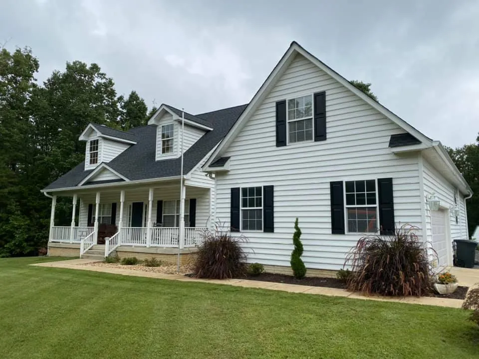 White Cape Cod home in Hollywood, MD with twin dormers, wraparound porch and a new black architectural shingle roof installed by Summit Exteriors