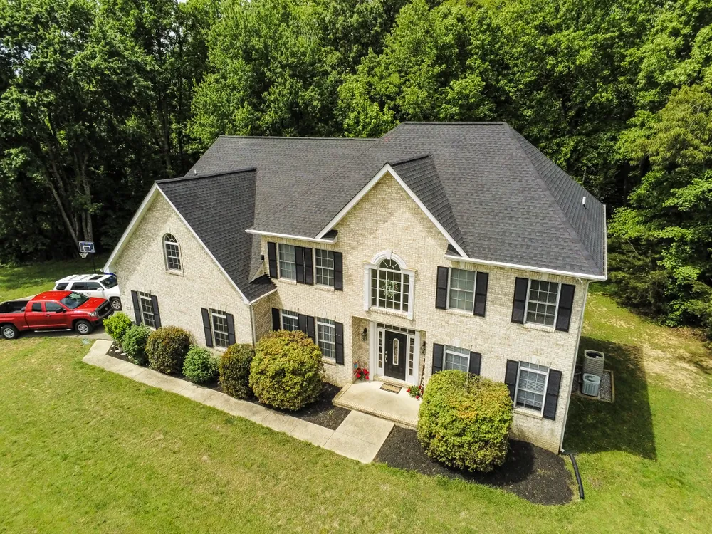 Brick colonial home in Bowie, MD with arched window and a new charcoal architectural shingle roof installed by Summit Exteriors