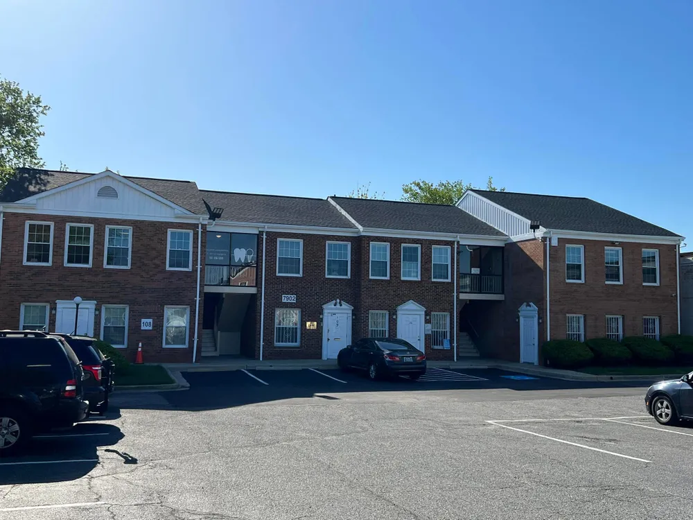 Two-story brick commercial office building in Waldorf, MD with a new dark architectural shingle roof installed by Summit Exteriors