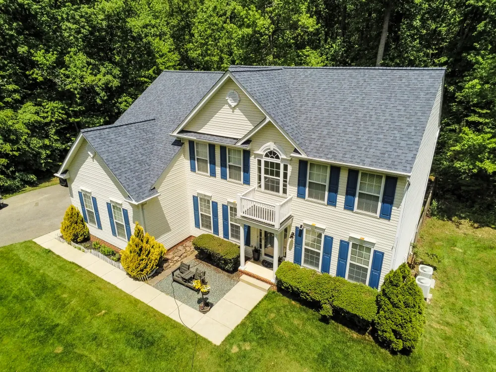 Two-story colonial home in Upper Marlboro, MD with blue shutters and a new dimensional asphalt shingle roof