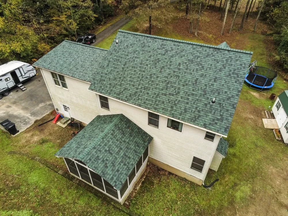 Two-story Mechanicsville, MD home tucked into the woods with a new green architectural shingle roof and screened porch