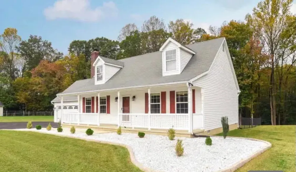 White Cape Cod home in Hollywood, MD with red shutters, covered porch and a new grey architectural shingle roof