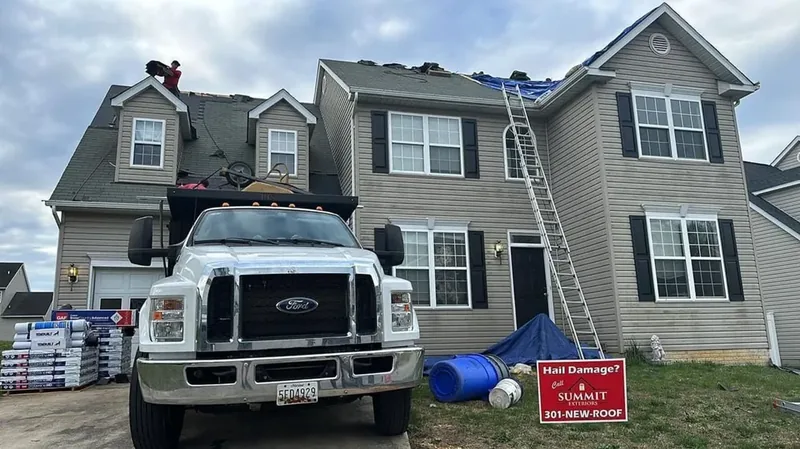 Summit Exteriors crew tearing off and replacing a hail-damaged roof on a two-story home in Waldorf, MD