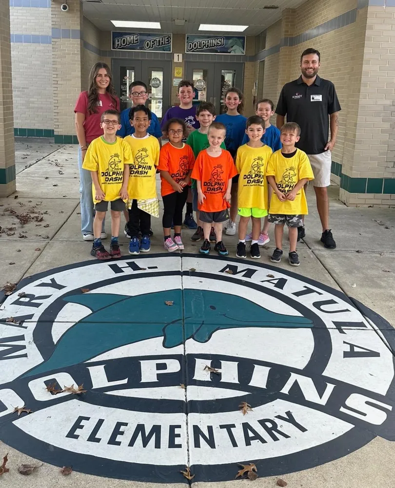 Summit Exteriors team member with students at the Mary H. Matula Elementary Dolphin Dash community event in La Plata, MD