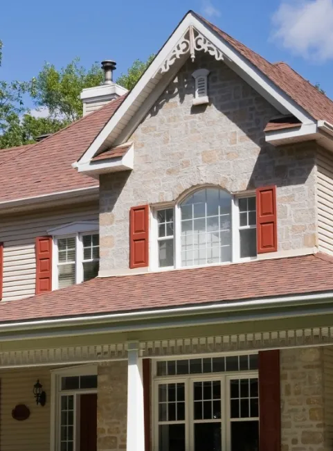 Stone-front Leonardtown, MD home with red shutters and a new red architectural shingle roof close-up