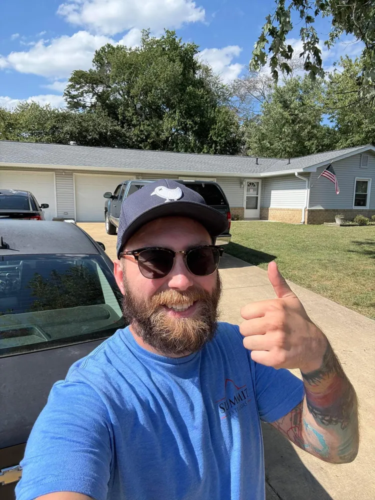 Summit Exteriors owner on-site at a Southern Maryland customer's home wearing a Summit Exteriors shirt and giving a thumbs up